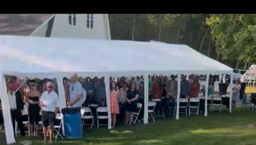20x40 white event tent set up for an outdoor wedding ceremony with seated guests